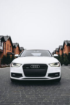 Vinnitsa; Ukraine; December 12, 2020: White Audi A4 (sedan; 4th generation; B8) standing on the street near the buildings. White car near the families houses