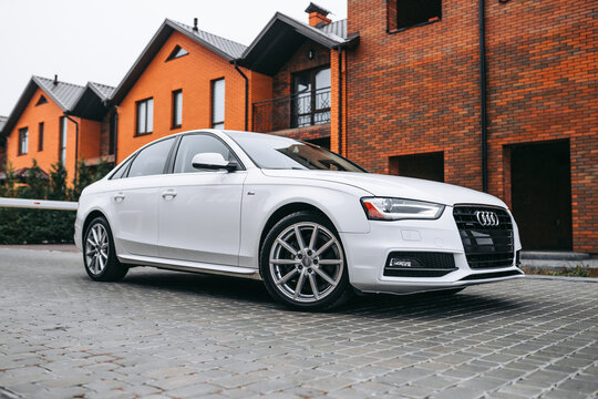 Vinnitsa; Ukraine; December 12, 2020: White Audi A4 (sedan; 4th generation; B8) standing on the street near the buildings. White car near the families houses