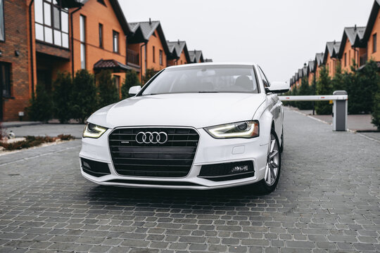 Vinnitsa; Ukraine; December 12, 2020: White Audi A4 (sedan; 4th generation; B8) standing on the street near the buildings. White car near the families houses