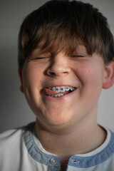 Smiling boy with dental braces showing healthy teeth. Child orthodontic treatment concept, close-up portrait, positive emotion, modern dentistry and oral care.
