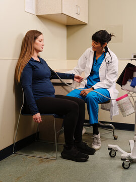 Native American nurse checks vital signs of pregnant patient