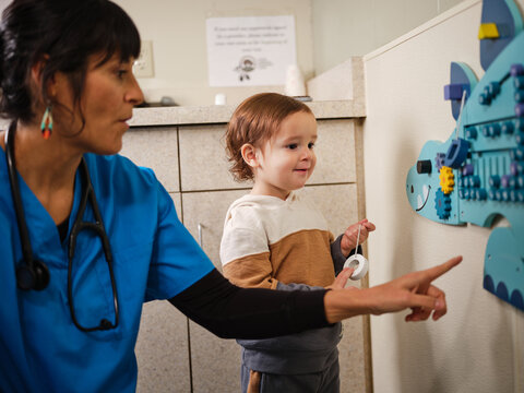 Native American toddler plays in clinic with nurse