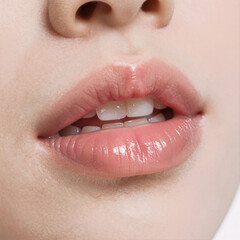 High-definition close up of glossy pink lips on a white background showcasing their smooth texture and natural beauty