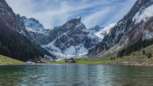 Time lapse, a scenic alpine lake surrounded by limestone cliffs and alpine pastures. Seealpsee view towards Saentis mountain peak, Appenzell Alps, Switzerland