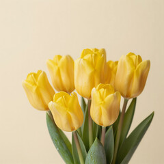 A yellow tulip arrangement against a light yellow background with ample room for text