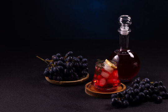 Grape cocktail with ice and decanted red liquid