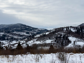Fototapeta premium Mystical snowy Carpathian peaks under cloudy skies