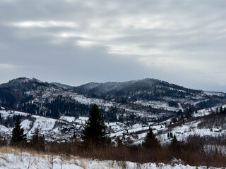 Mystical snowy Carpathian peaks under cloudy skies