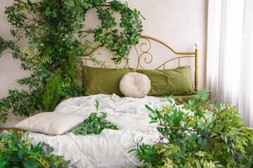 Cozy bedroom adorned with lush greenery and natural spring decor for tranquil atmosphere. Gold forged headboard, bed with soft green bedding. Lush plants creating peaceful relax elements and comfort.