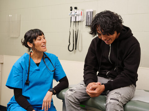 Native American boy chats with nurse about health in clinic