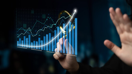 A businessman focuses on financial data analysis using a transparent display showcasing graphs and charts, illustrating growth trends in a modern office setup. Impute
