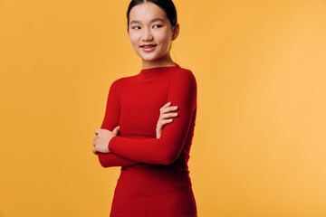 Obraz premium Young woman smiling with crossed arms in red long sleeve shirt against yellow background. Portrait of confident female with casual outfit and natural makeup for lifestyle concept.