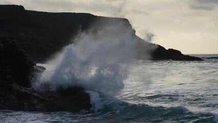 Obraz premium Spectacular sunset contemplating the force of the sea crashing agains the cliff