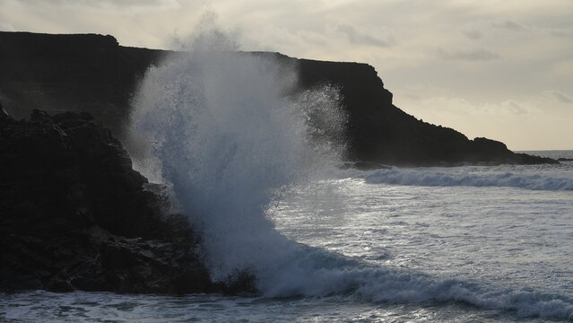 Spectacular sunset contemplating the force of the sea crashing agains the cliff