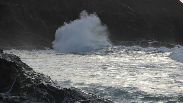 Spectacular sunset contemplating the force of the sea crashing agains the cliff