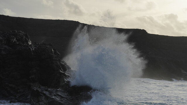 Spectacular sunset contemplating the force of the sea crashing agains the cliff