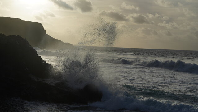 Spectacular sunset contemplating the force of the sea crashing agains the cliff