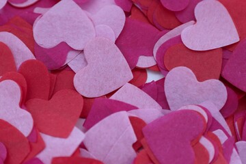 Obraz premium Layers of pink and red paper hearts — a romantic textured background for design, advertising, and Valentine's Day
