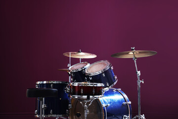 Obraz premium Modern drum kit on burgundy background, closeup. Space for text