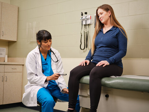 Indigenous healthcare worker checks woman's knees