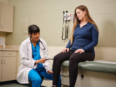 Native American nurse uses hammer for reflex check