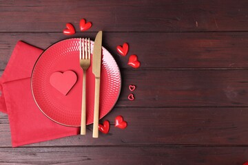 Naklejka premium Valentine's Day. Elegant setting with cutlery and decorative hearts on wooden table, flat lay. Space for text