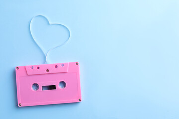 Music cassette and heart made with tape on light blue background, top view. Space for text