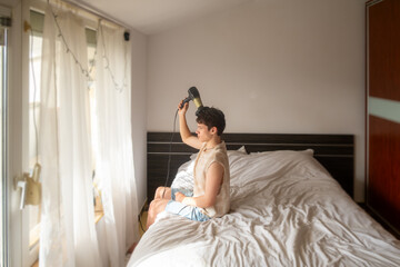 17-year-old teenage boy blow-dries his hair, hair styling, personal care, teenage mood concept