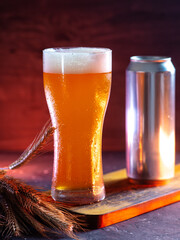 Cold wheat beer in a tall glass, poured from aluminum can. Unfiltered beer