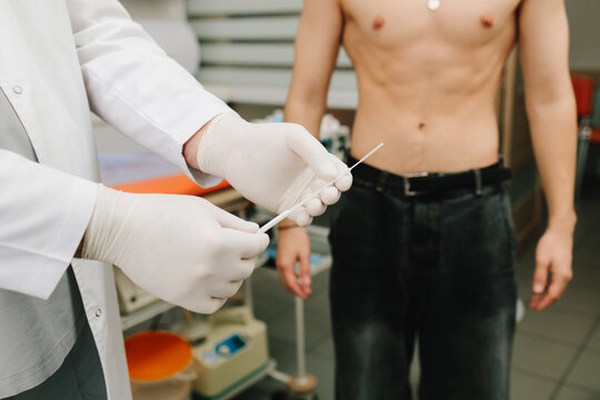 Sterile swab in urologist hands during urology exam preparation.