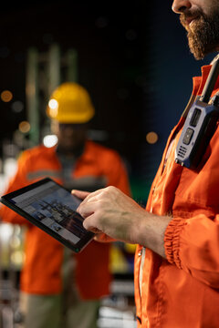 Close up of offshore platform engineer checking equipment status indicators on tablet system dashboard. Worker verifying hydraulic pressure levels on device digital monitoring panel app