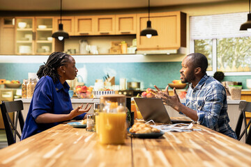 Frustrated black couple fighting over irresponsible debts and expenses, blaming each other and...