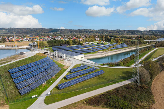 Renewable energy infrastructure features a hydro power plant paired with solar panels in an aerial perspective focusing on sustainability.