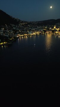 Cinematic drone footage of Como Lake at night with moonlight and city lights reflecting on the mirror-like water in vertical format for social media 2