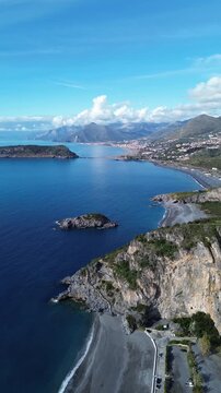 Spectacular vertical drone footage of Dino Island near Praia a Mare Calabria showcasing the coast and the contrast between the blue sea and green mountains 2