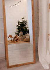 Christmas tree reflection in mirror with rocking horse and decorations