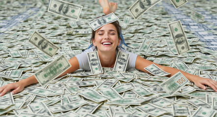 Happy young woman lying in a huge pile of money with cash falling around her. Excited lottery winner celebrating financial success with US dollar bills