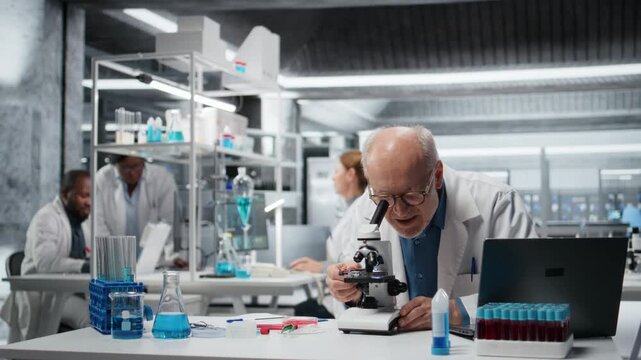 Laboratory materials scientist examining biopsy slide with microscope, logging results on clipboard. Senior researcher identifies disease markers in clinical lab, writing report, camera A