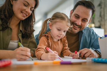 Fototapeta premium Happy family enjoying creative activity drawing with daughter