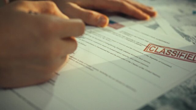 A male government official carefully examines a confidential document detailing bilateral cooperation between two nations, stamped with a high-security classification