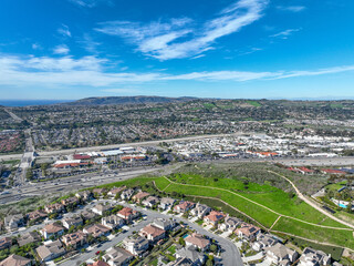 Fototapeta premium Aerial view over San Juan Capistrano, California, featuring the historic mission, library, sports courts, and an Amtrak train pulling into the downtown station. High quality 4k footage