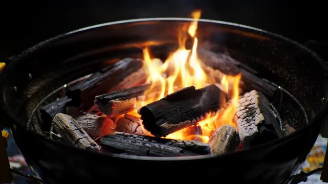 Close-up of burning charcoal in a barbecue grill, creating a warm and inviting atmosphere.