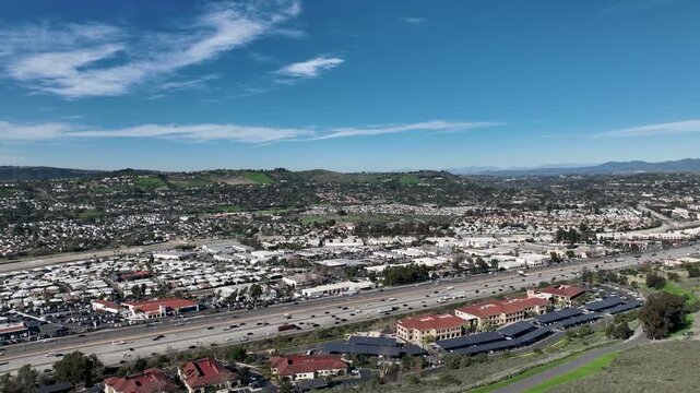 Aerial view over San Juan Capistrano, California, featuring the historic mission, library, sports courts, and an Amtrak train pulling into the downtown station. High quality 4k footage