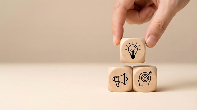 hand placing wooden block with light bulb on top of other blocks