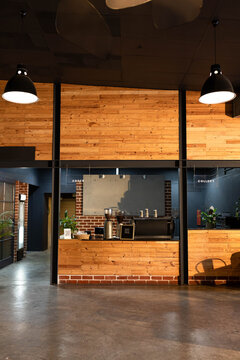 Wooden counter is featuring espresso machine, grinders, milk jugs and ORDER COLLECT signs at cafe