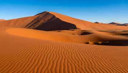 Majestic orange sand dunes under a clear blue sky