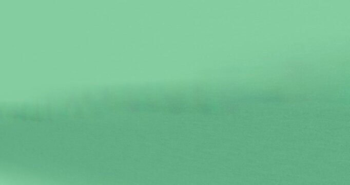 Off-frame light shifting, gray diagonal band sweeping across paper fading on transparent background