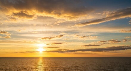 Fototapeta premium Golden sun sets over calm ocean, painting sky with vibrant hues. Clouds reflect the warm light