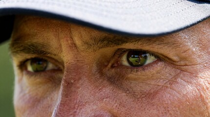 Focus: Extreme close-up of a golfer's eyes, reflection of the green in the iris, intense concentration.
