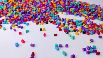 Obraz premium Various colors of masterbatch granules mixed on a white background.Color pigment carrier polymers in the plastics industry